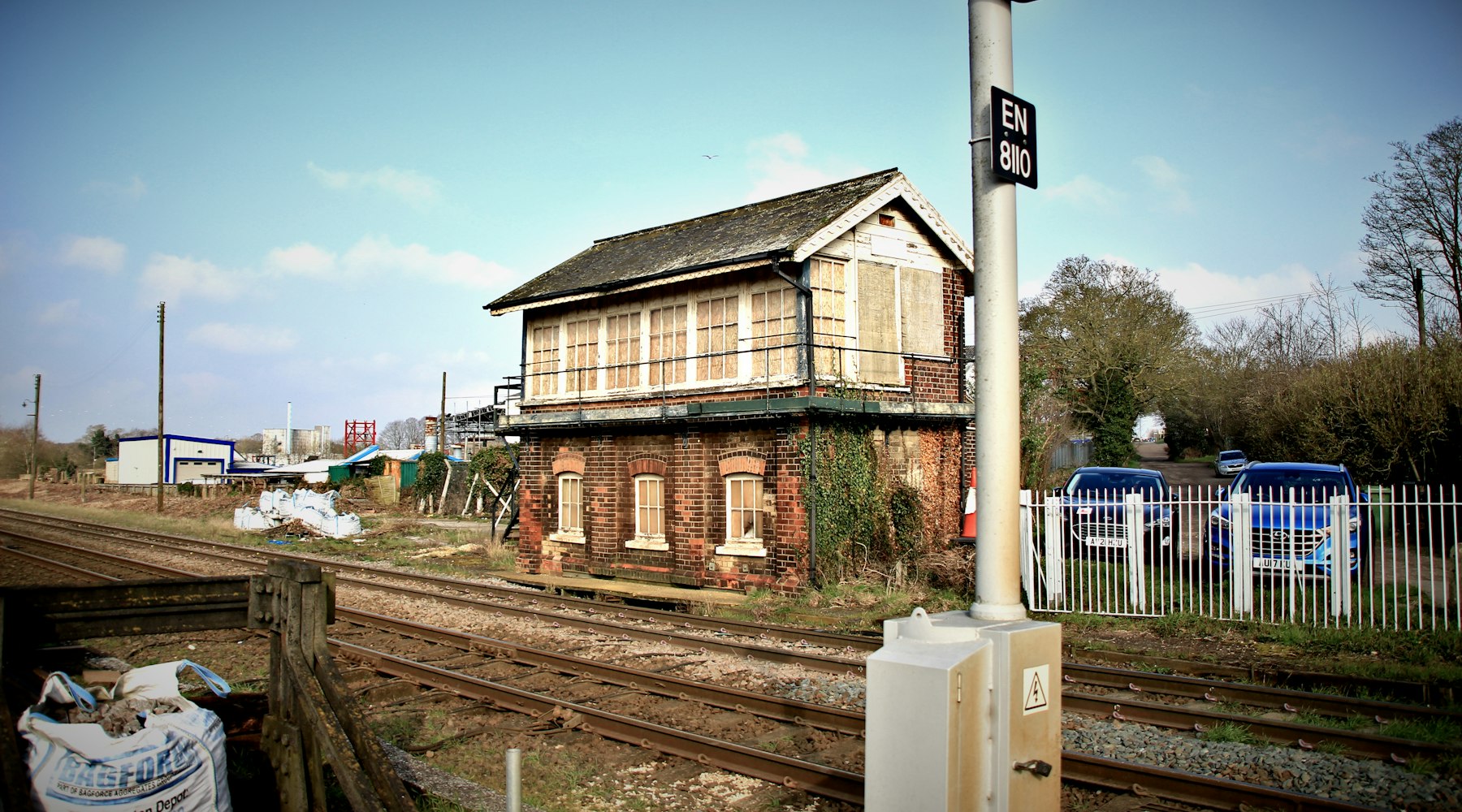 Antiga cabine de sinalização ferroviária ao lado dos trilhos.