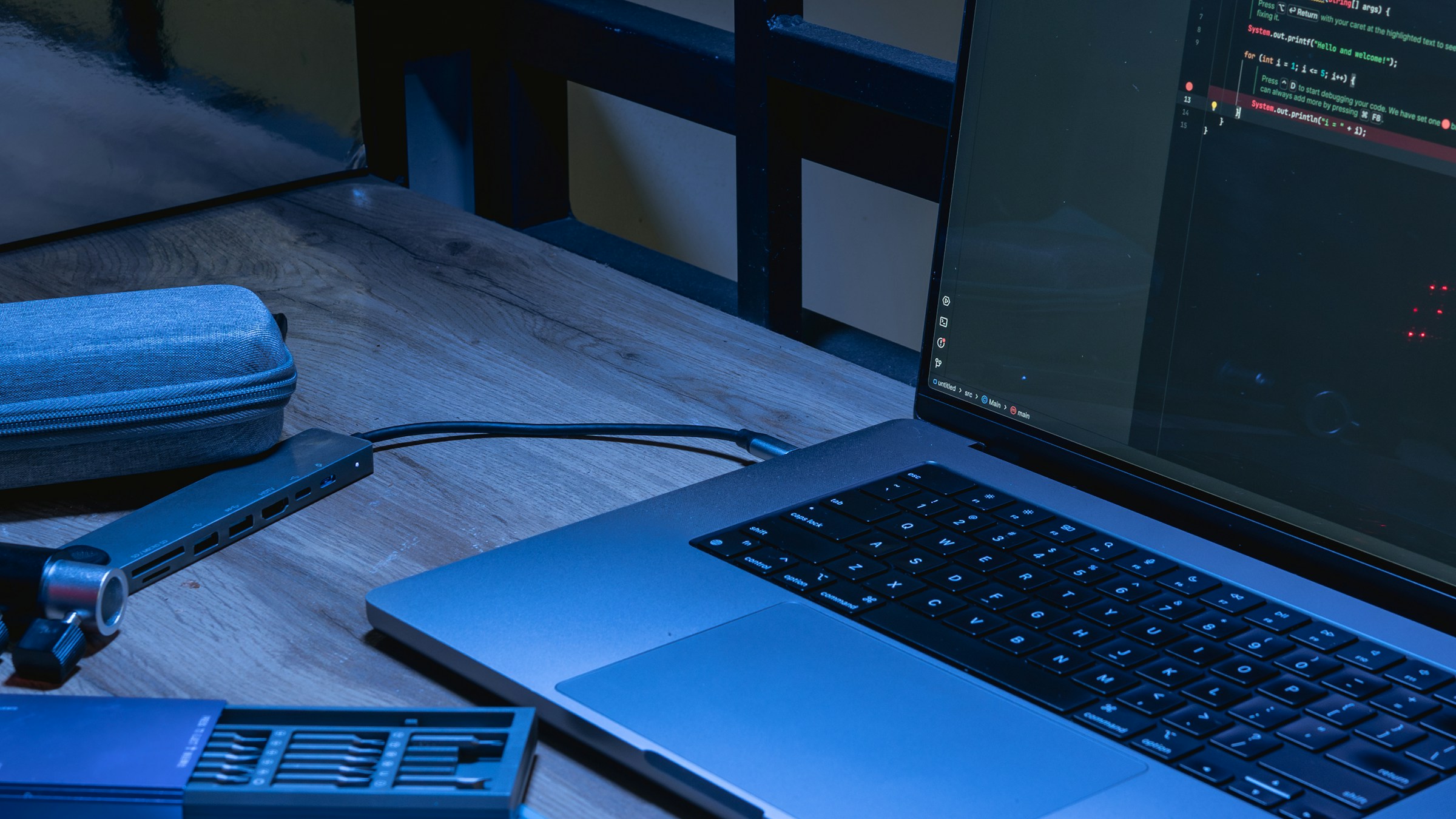 Laptop exibindo código-fonte sobre uma mesa, representando a transição da assistência de código para a orquestração de agentes.